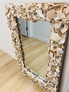 a mirror made out of seashells on the floor