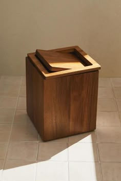 a wooden box sitting on top of a tiled floor