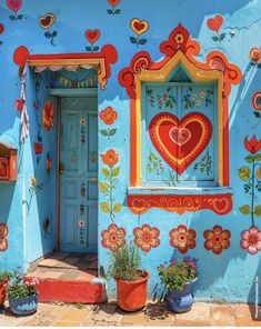 a blue building with flowers and hearts painted on the front door is decorated in bright colors