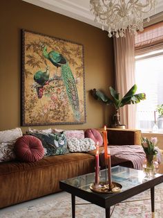 a living room with a couch, coffee table and painting on the wall above it