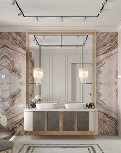 a bathroom with two sinks, mirrors and lights on the wall above it is a marble floor