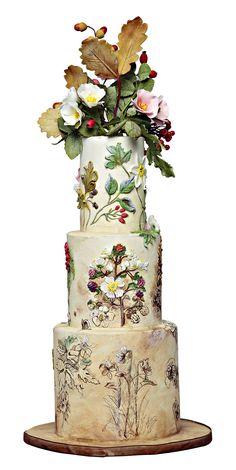 a three tiered cake decorated with flowers and leaves