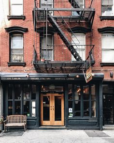 an old brick building with stairs leading up to the door and two benches in front