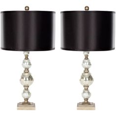 a pair of lamps with black shades and silver balls on each lamp, one is turned off