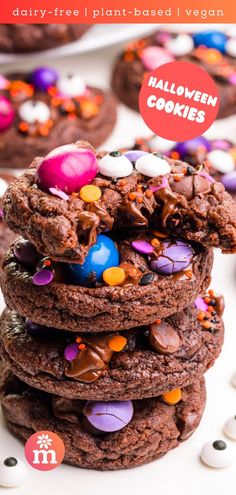 a stack of chocolate cookies with candy on top and the title overlay reads, dairy - free plant - based vegan halloween cookies