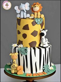 a three tiered cake decorated with animals and giraffes