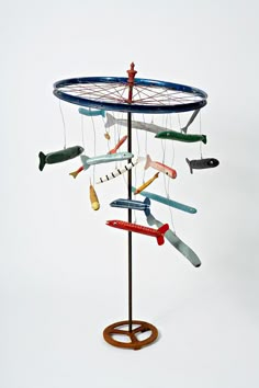 a metal sculpture with many different types of scissors hanging from it's sides