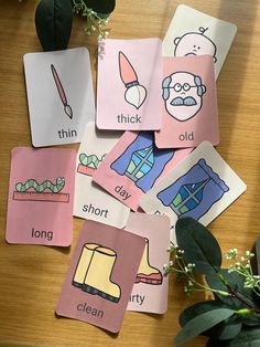 several cards with words and pictures on them sitting on a table next to a potted plant