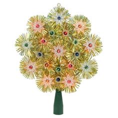 a green vase filled with lots of gold and red flowers on top of a white table