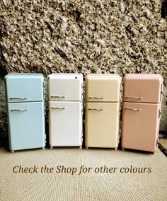 four miniature refrigerators sitting next to each other in front of a stone wall with the words check the shop for other colours