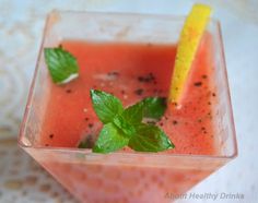 a drink in a glass garnished with mint and lemon