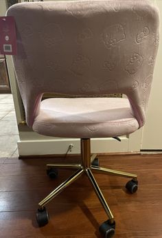 an office chair with hello kitty fabric on it's back and wheels, in front of a door