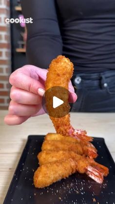 a person is holding up some fried food