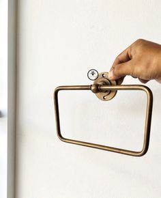 a hand is holding onto the handle of a toilet roll holder