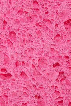 the surface of a pink substance with small holes in it