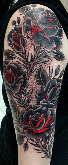 a woman's arm with black and red flowers on the left side of her body