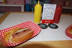 a hot dog with mustard and ketchup in a basket next to some fries