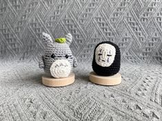 two small crocheted animals sitting on top of wooden bases next to each other