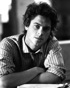 black and white photograph of a young man wearing a striped shirt, tie and vest