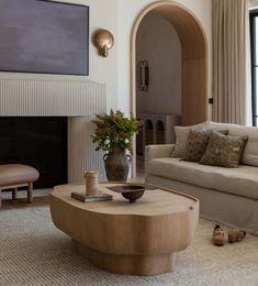 a living room filled with furniture and a fire place next to a large painting on the wall