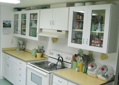 a kitchen with white cabinets and yellow counter tops