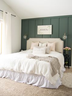 a bedroom with green walls and white bedding