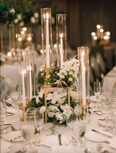 a table topped with lots of white flowers and candles