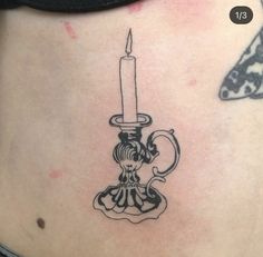 a woman's stomach with a candle tattoo on it