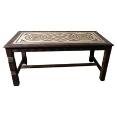 a wooden table with an intricate design on the top and bottom, sitting against a white background