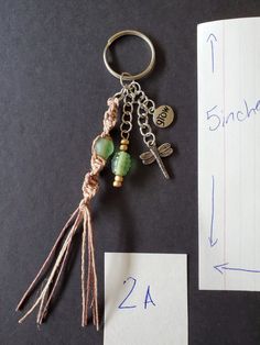 a keychain with some charms attached to it next to a piece of paper