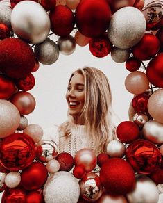 a woman is surrounded by red and silver ornaments