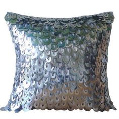 a decorative pillow with silver and green sequins on the front, sitting on a white background