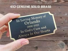 a person holding up a plaque that says in loving memory of orlando