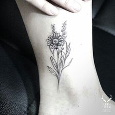 a woman's foot with a flower tattoo on it