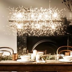 a dining room table with plates, cups and saucers on it in front of a fireplace