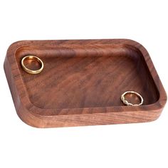 a wooden tray with two gold rings on the bottom and one ring in the middle