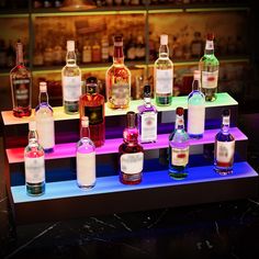 several different types of alcohol bottles lined up on a shelf in front of a bar