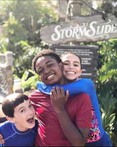 two boys hugging each other in front of a sign that says storm slide on it