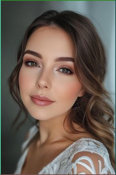 a woman with long hair wearing a white top and brown eyeshadow is looking at the camera