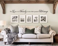 a living room with couches and pictures hanging on the wall above it's headboard