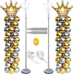 two tall gold and silver balloons with crowns on them, standing next to each other