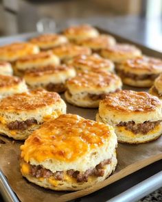 biscuits with cheese and meat are on a baking sheet