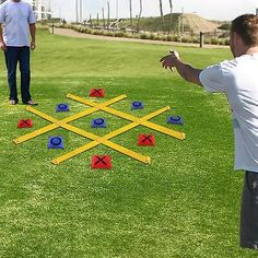 two men standing on top of a lush green field next to a frisbee golf game