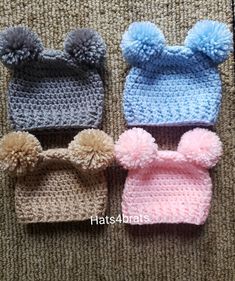 three crocheted hats with pom - poms on them