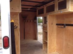 the inside of a horse trailer with its door open and shelves in place for storage