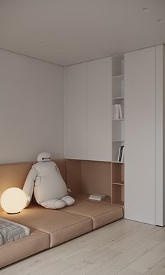 a room with a bed, bookshelf and lamp on the floor in front of it