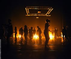 a group of people standing around in front of a stage with bright lights on it