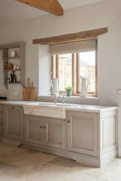 a kitchen with an open window, sink and counter top in front of the windows