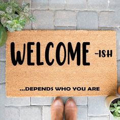 a welcome mat with the words,'welcome - ish'on it next to potted plants