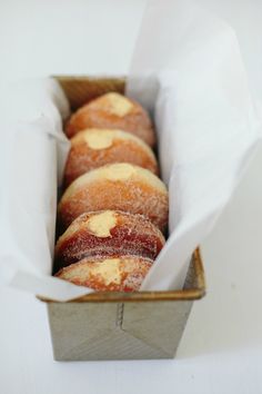 a box filled with donuts covered in icing on top of a white table